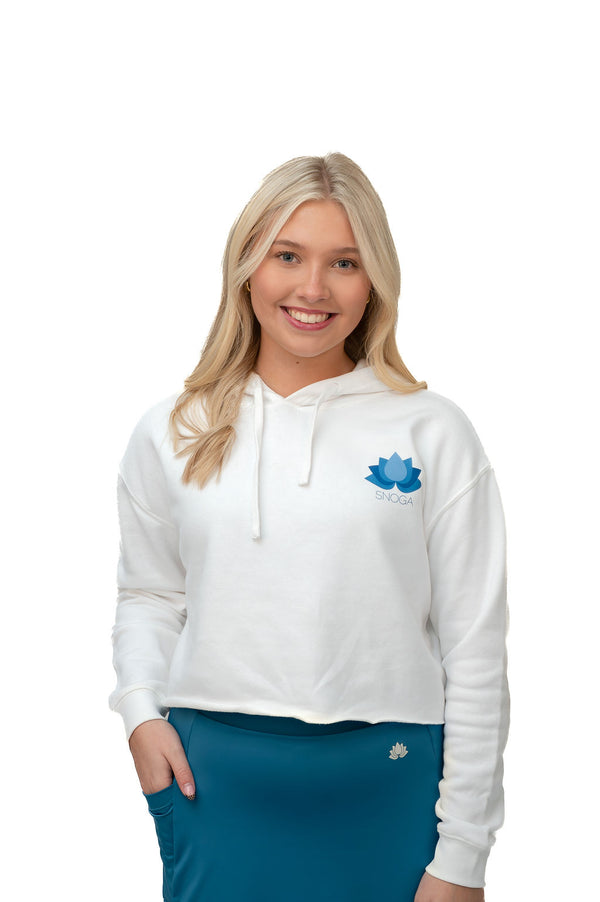 Woman wearing white Snoga Athletics hoodie and blue activewear skirt, smiling, studio background