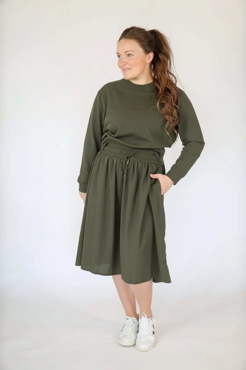 Olive drawstring tech high-rise skirt by Courtney Toliver, featuring a sleek design and comfortable fit with functional drawstrings.