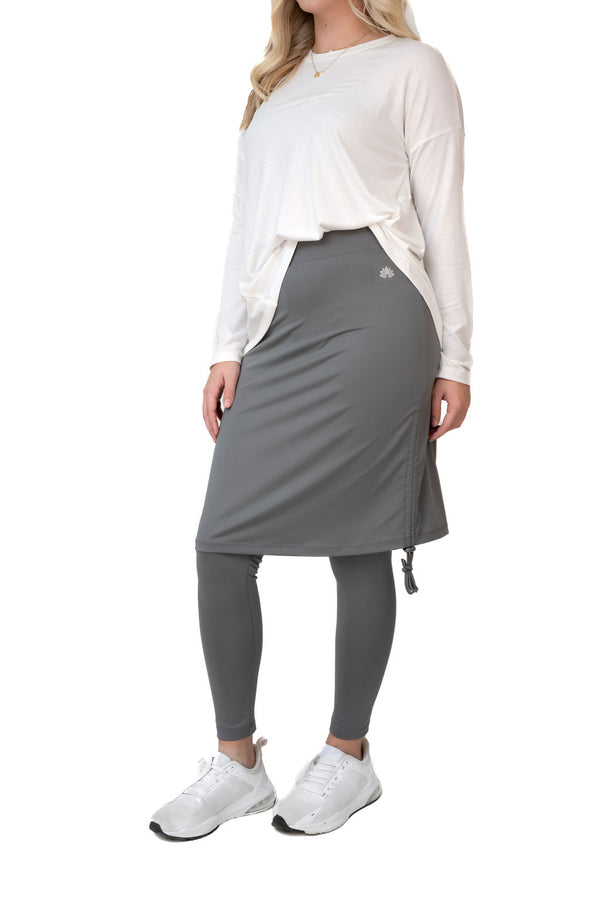 Snoga Athletics model in modest activewear, gray skirted leggings, white top, white sneakers