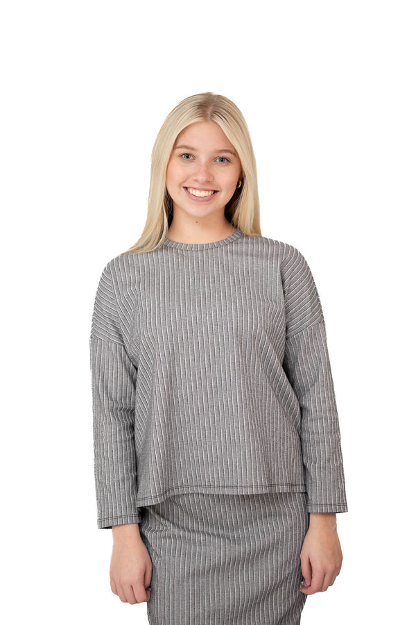 Woman in grey pinstripe modest top and skirt set from Snoga Athletics