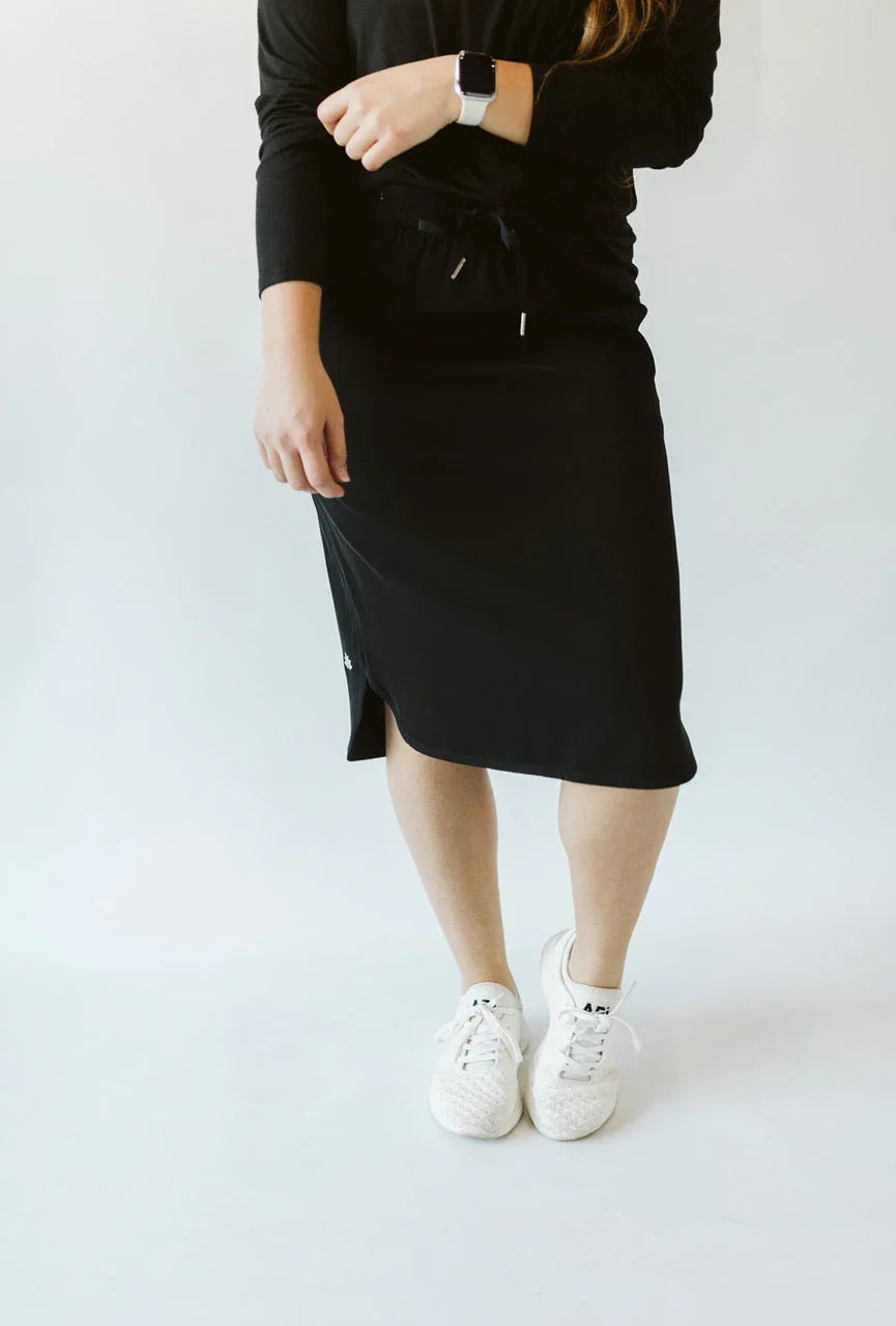 Woman wearing Snoga Athletics black everyday skirt with drawstring, white sneakers