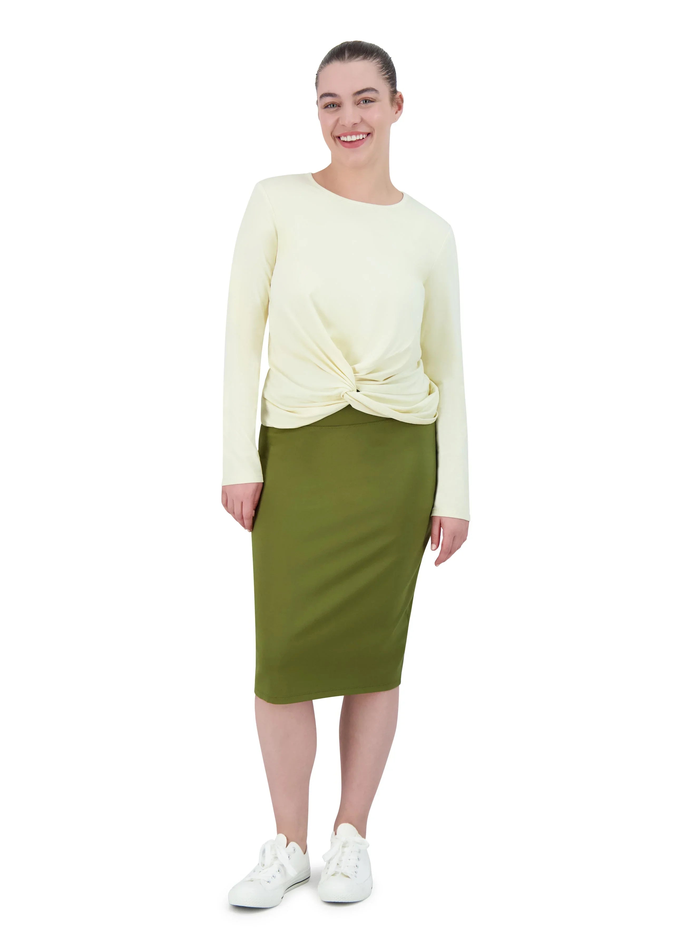 Woman modeling olive green knee-length ponte pencil skirt by Snoga Athletics, paired with a cream long-sleeve top and white sneakers.