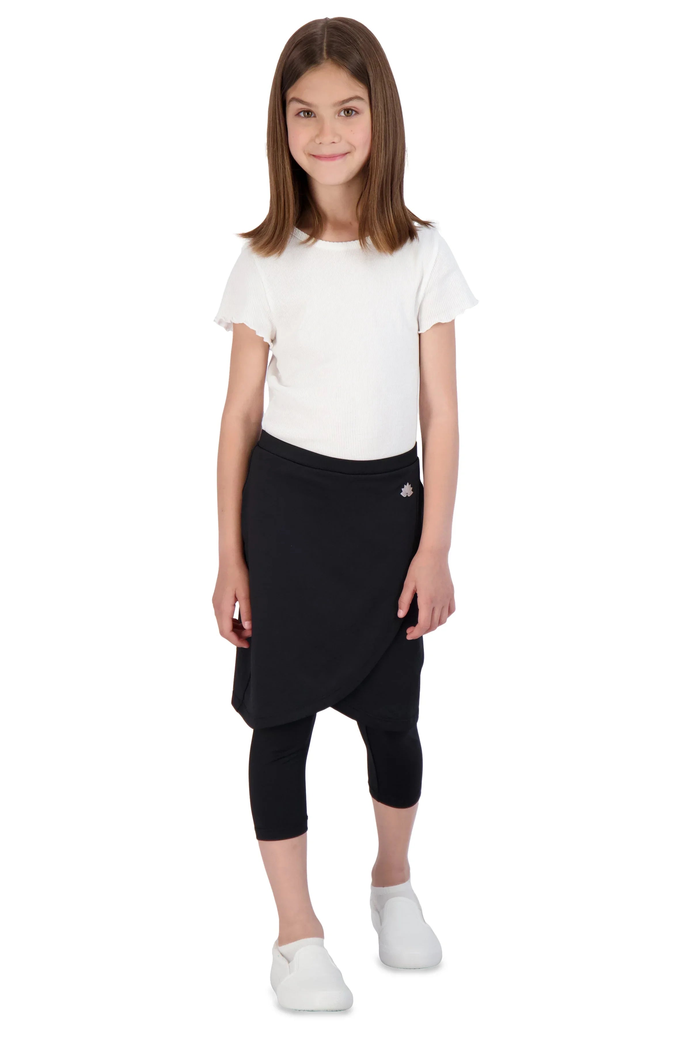 Girl in Snoga Athletics black faux wrap skirt leggings, white top, and white shoes