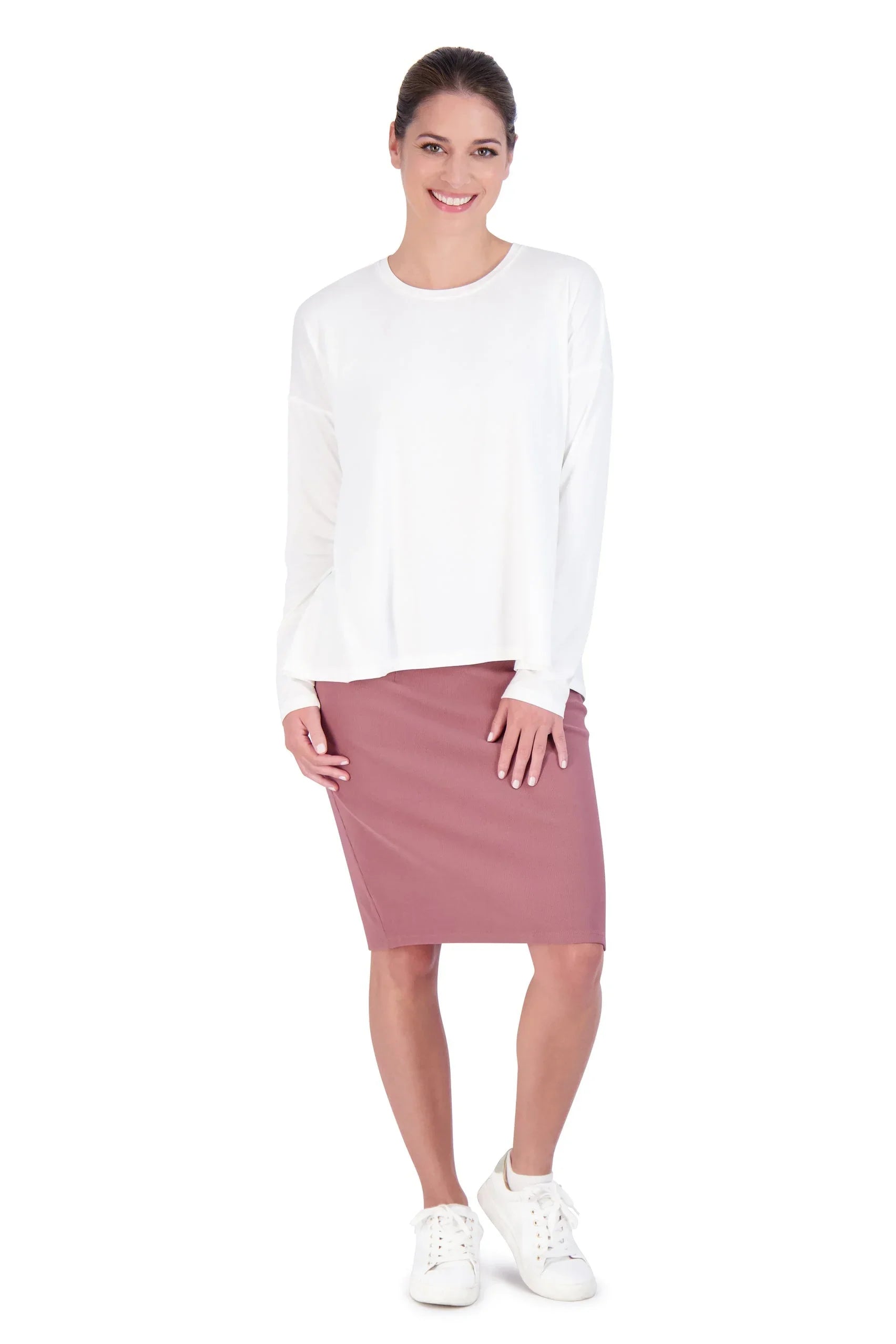 Woman modeling Snoga Athletics white long sleeve shirt with mauve skirt and white sneakers