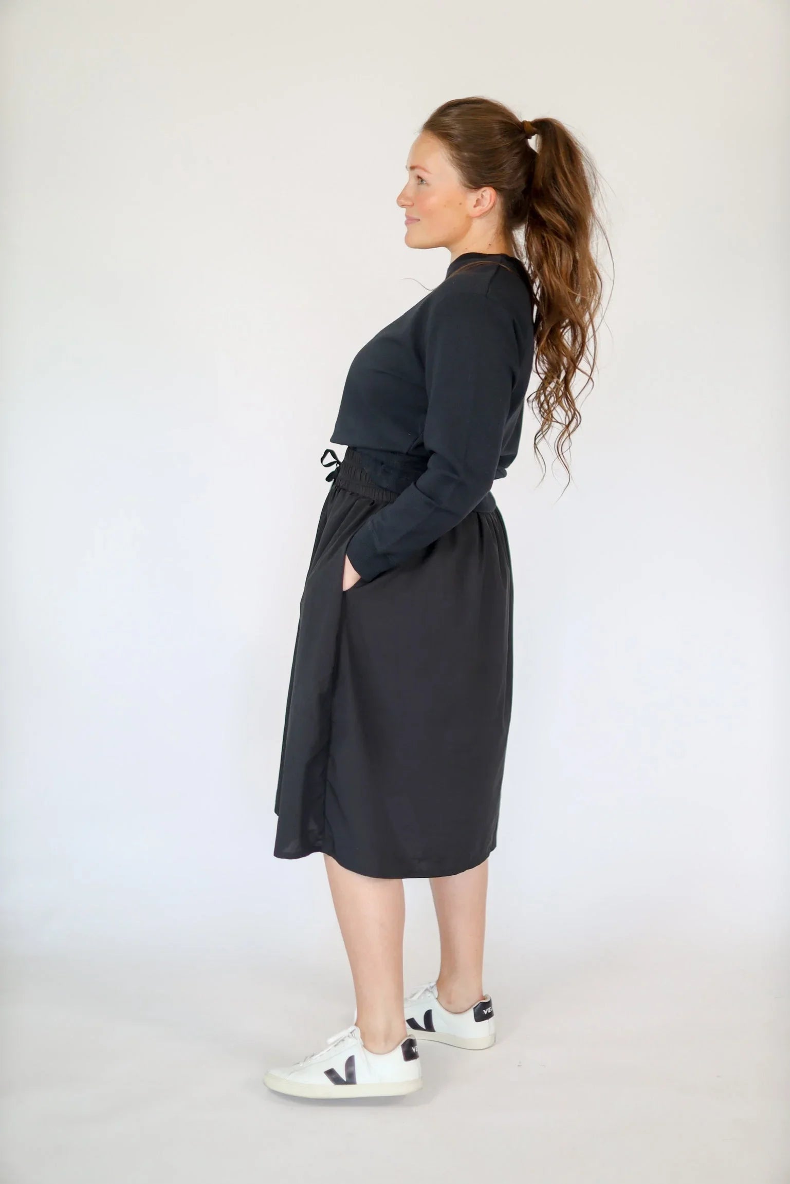 Woman wearing Snoga Athletics black drawstring tech high-rise skirt with pockets