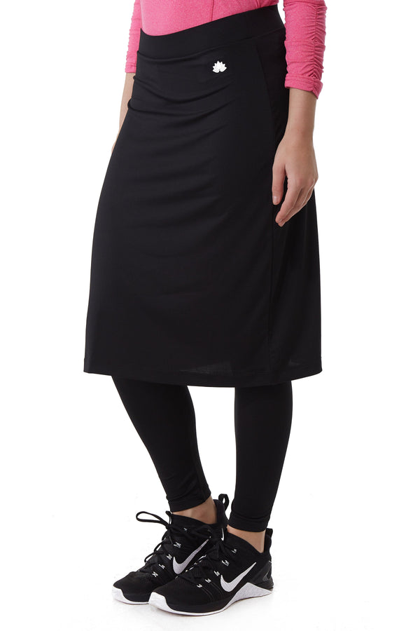 Snoga Athletics black ankle midi skirt with attached leggings, worn by a woman in athletic shoes