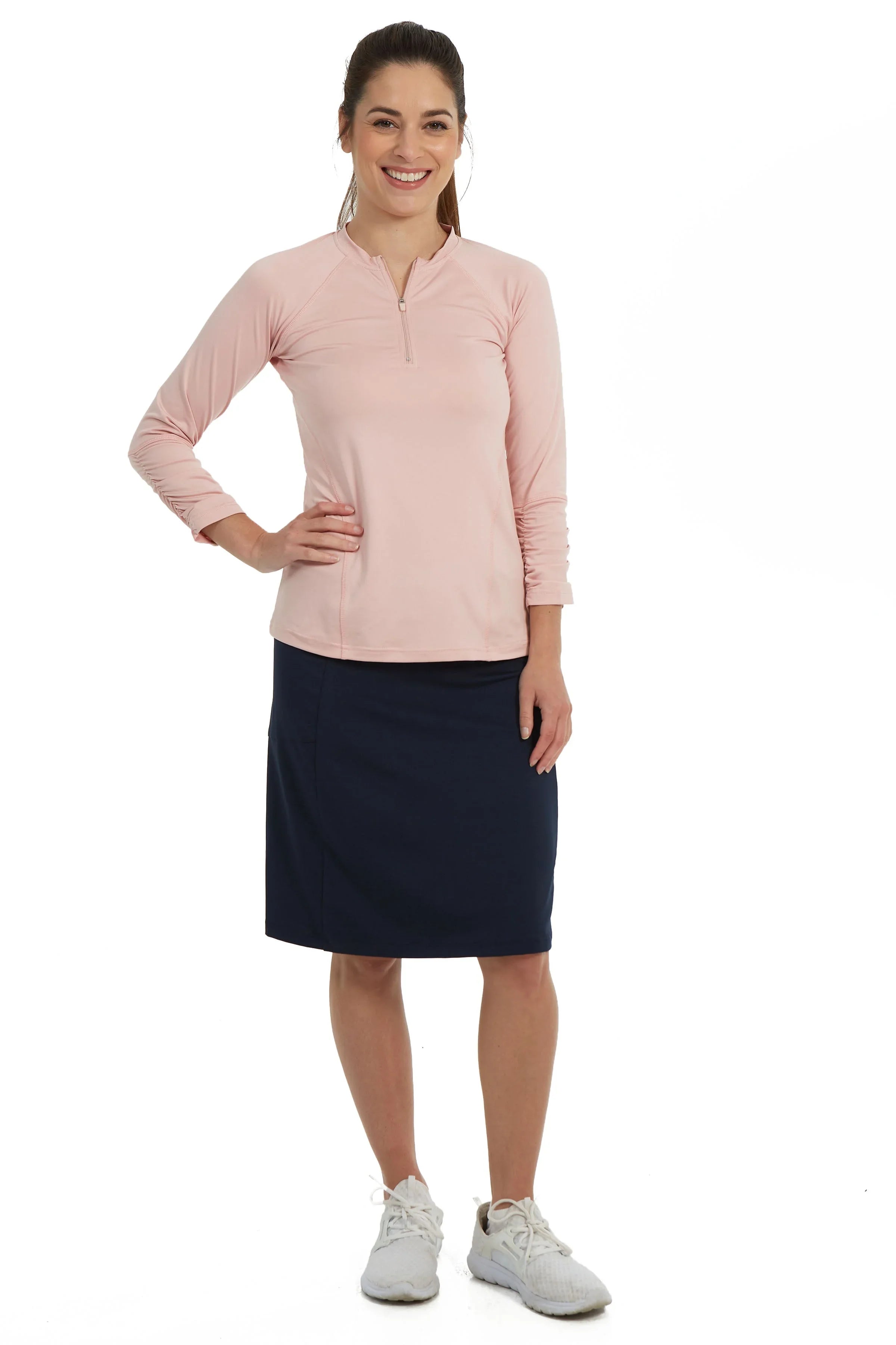Woman wearing Snoga Athletics navy fit skort and light pink long sleeve active top
