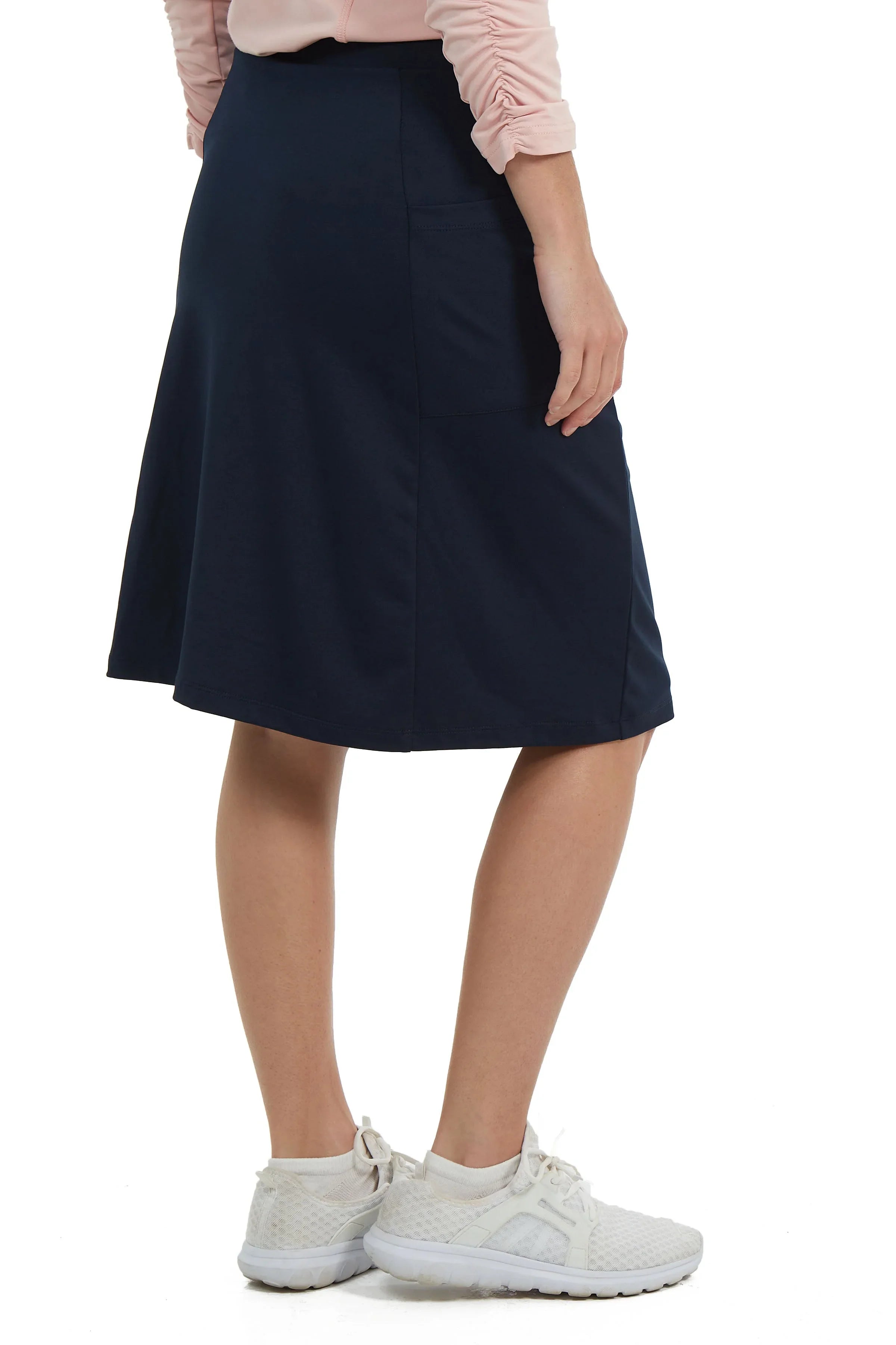 Woman wearing navy blue athletic skort by Snoga Athletics, side pocket detail visible