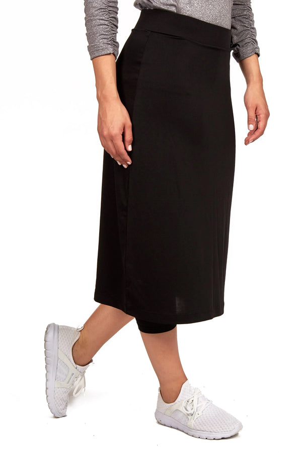 Woman wearing Snoga Athletics black midi active skirt with leggings and white sneakers