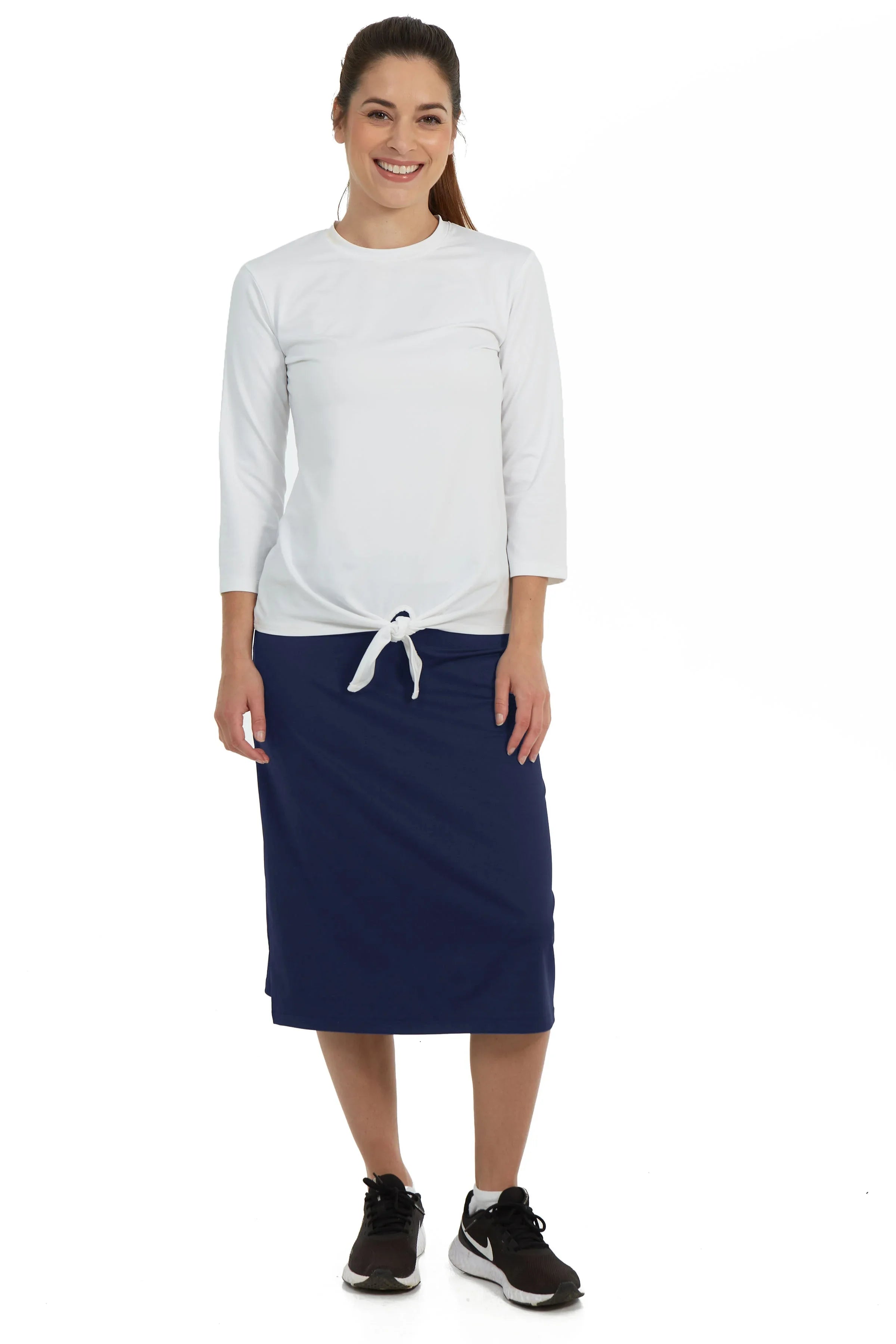 Woman wearing Snoga Athletics navy midi skirt with attached shorts and white top