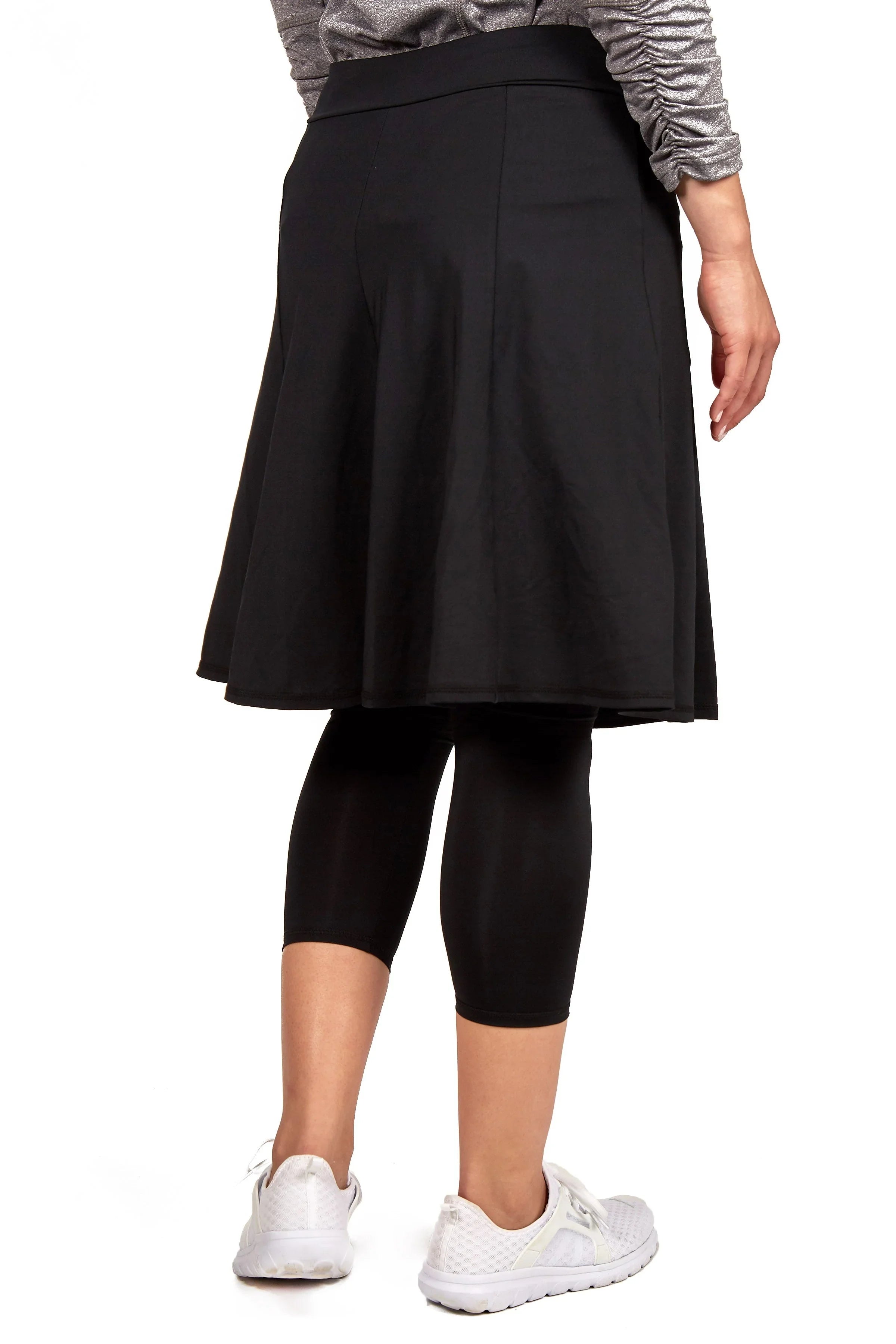 Woman wearing Snoga Athletics black modest skirt with attached leggings, back view.