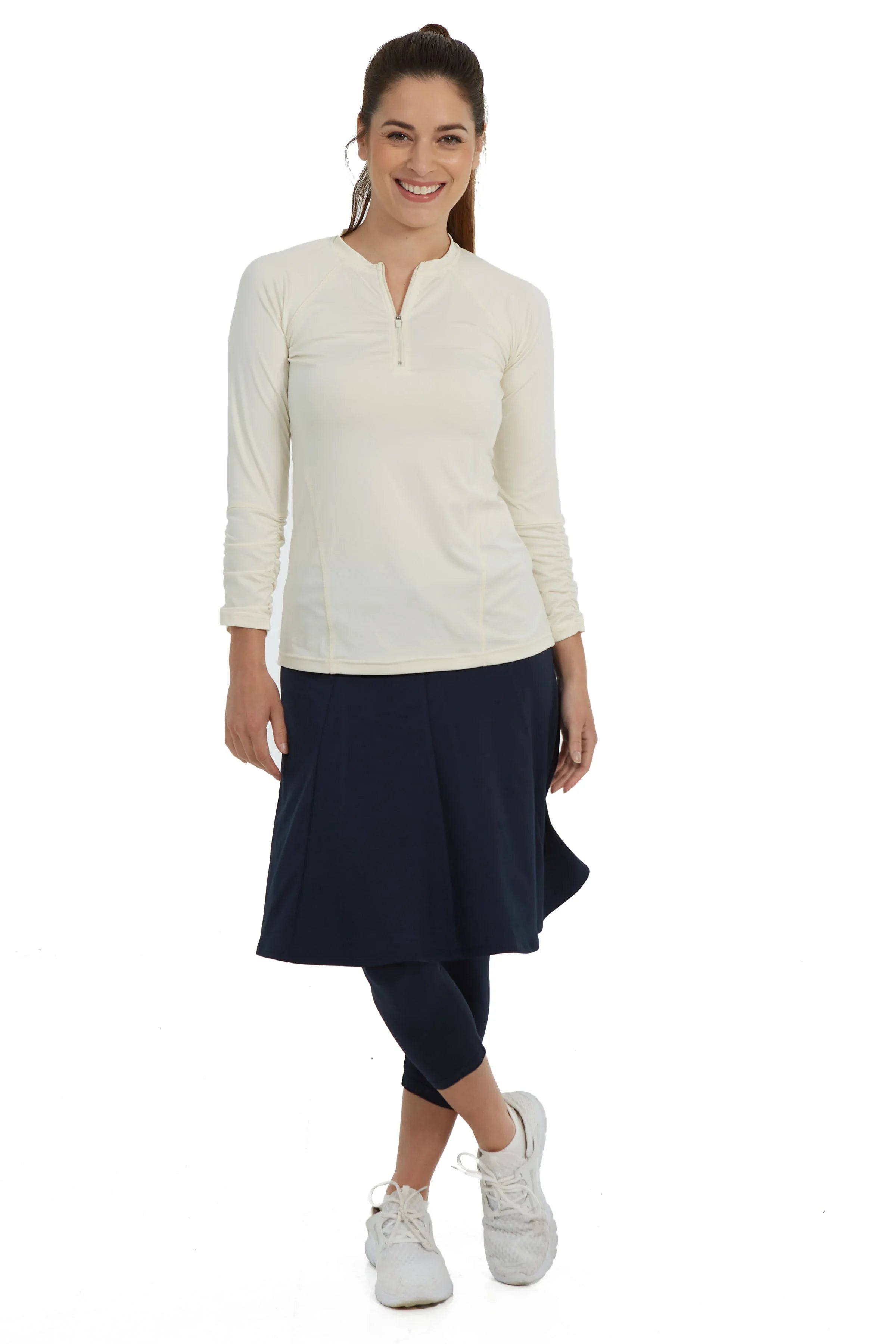 Woman wearing Snoga Athletics navy skirted leggings and cream zip top, activewear fashion