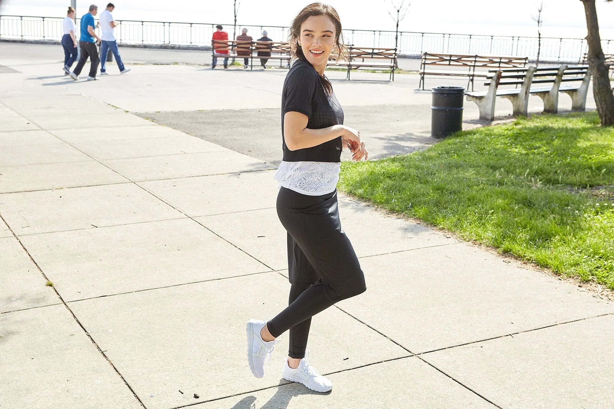 Woman outdoors wearing Snoga Athletics long black shirt tail leggings, white sneakers