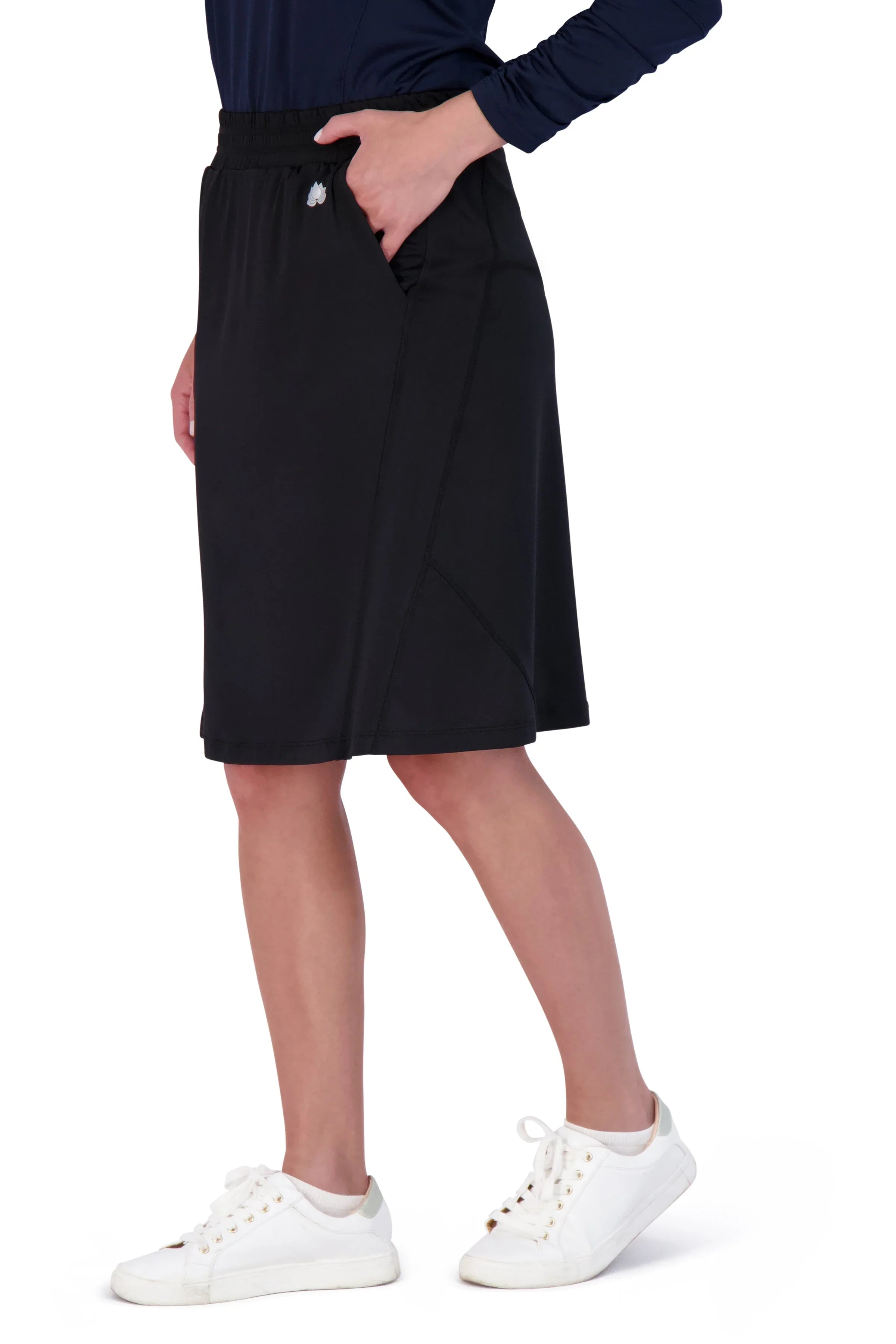Snoga Athletics black travel skirt with elastic waistband and side pockets, worn with white sneakers