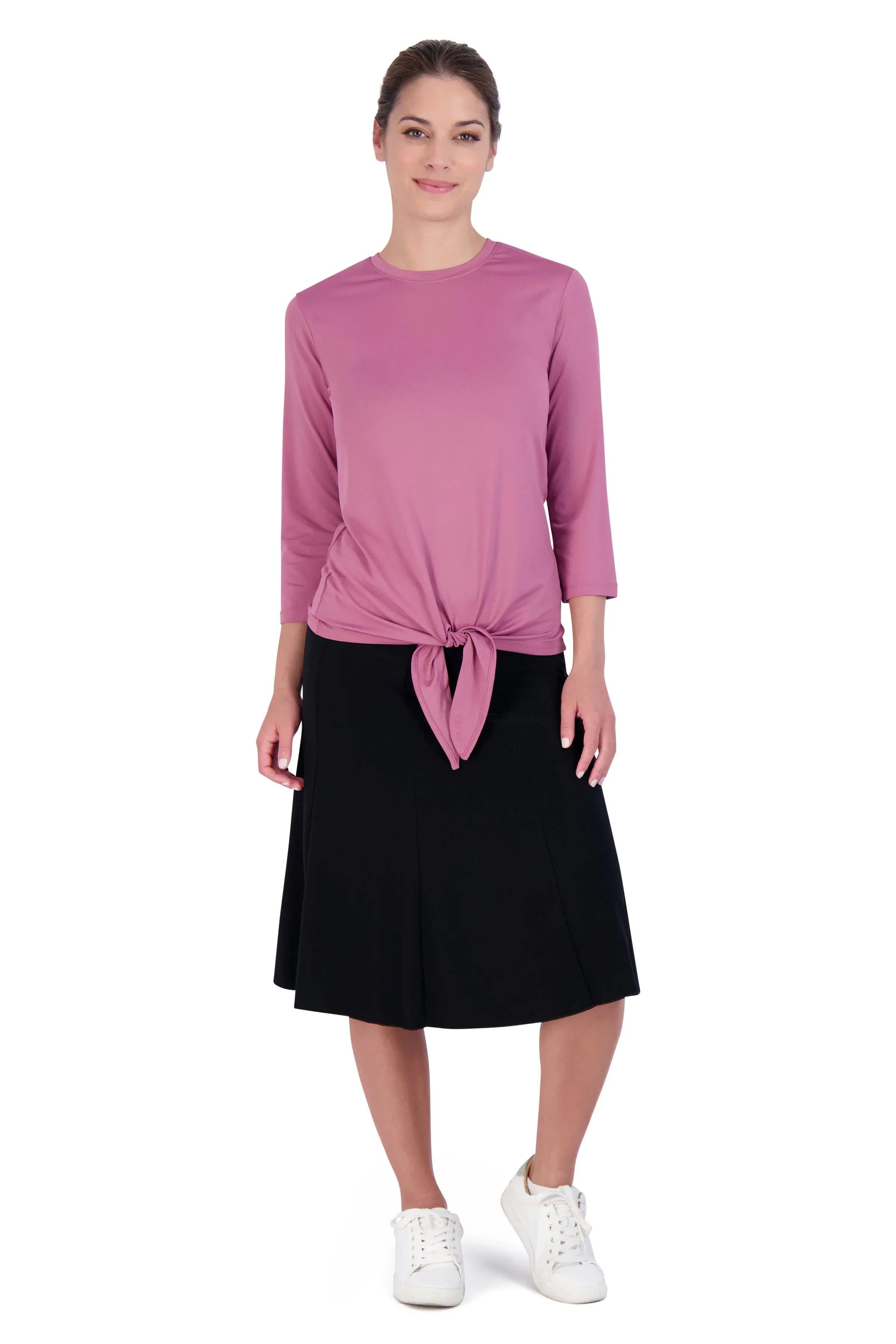 Woman wearing Snoga Athletics black twirly skirt with modest pink tie top and white sneakers