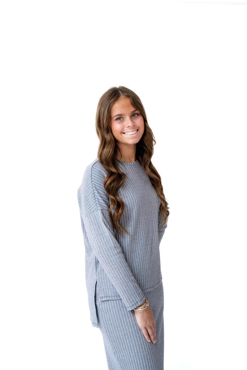 Woman in Snoga Athletics striped knit top and matching skirt, modest activewear on white background