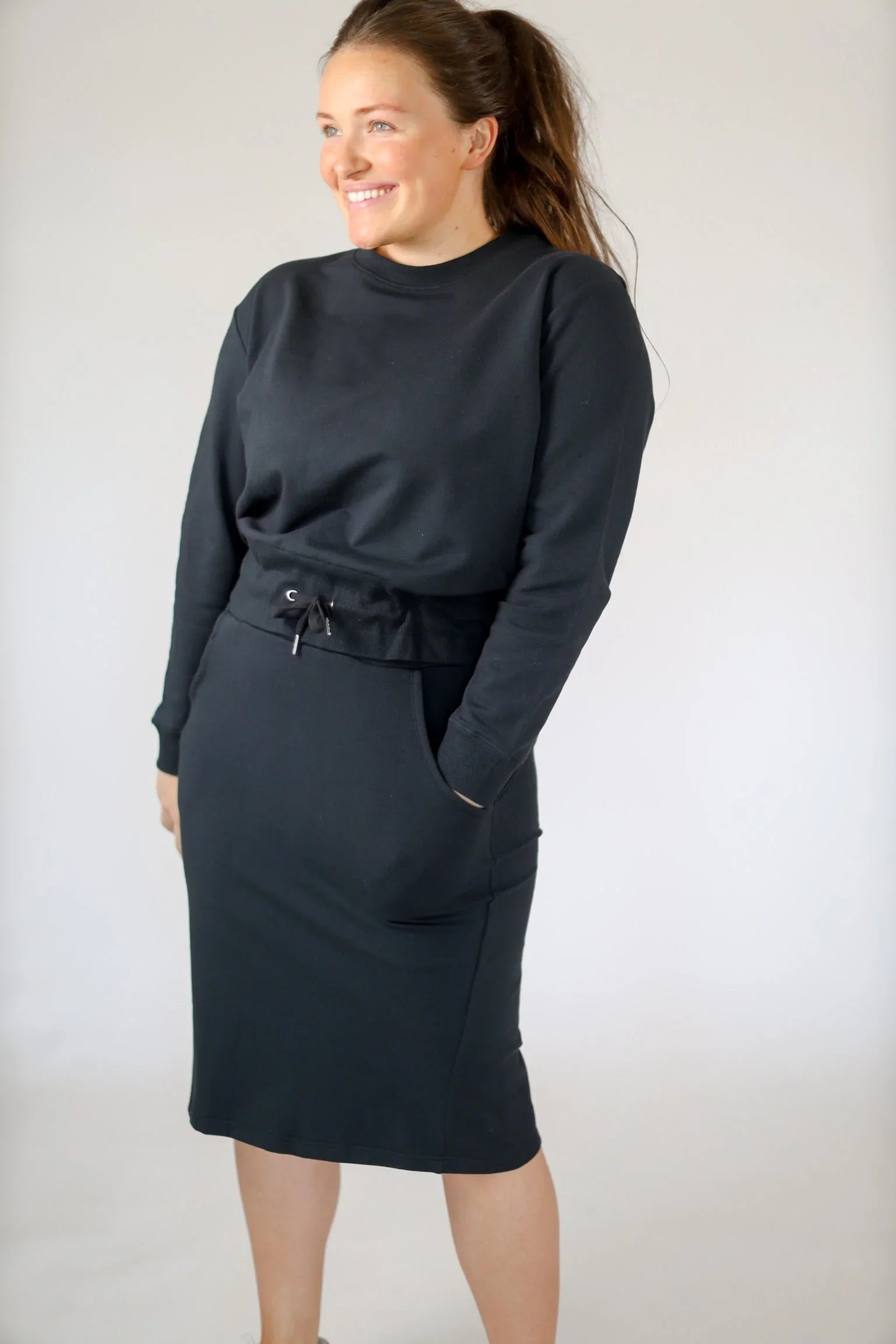 Woman wearing black cropped drawstring pullover sweatshirt by Snoga Athletics