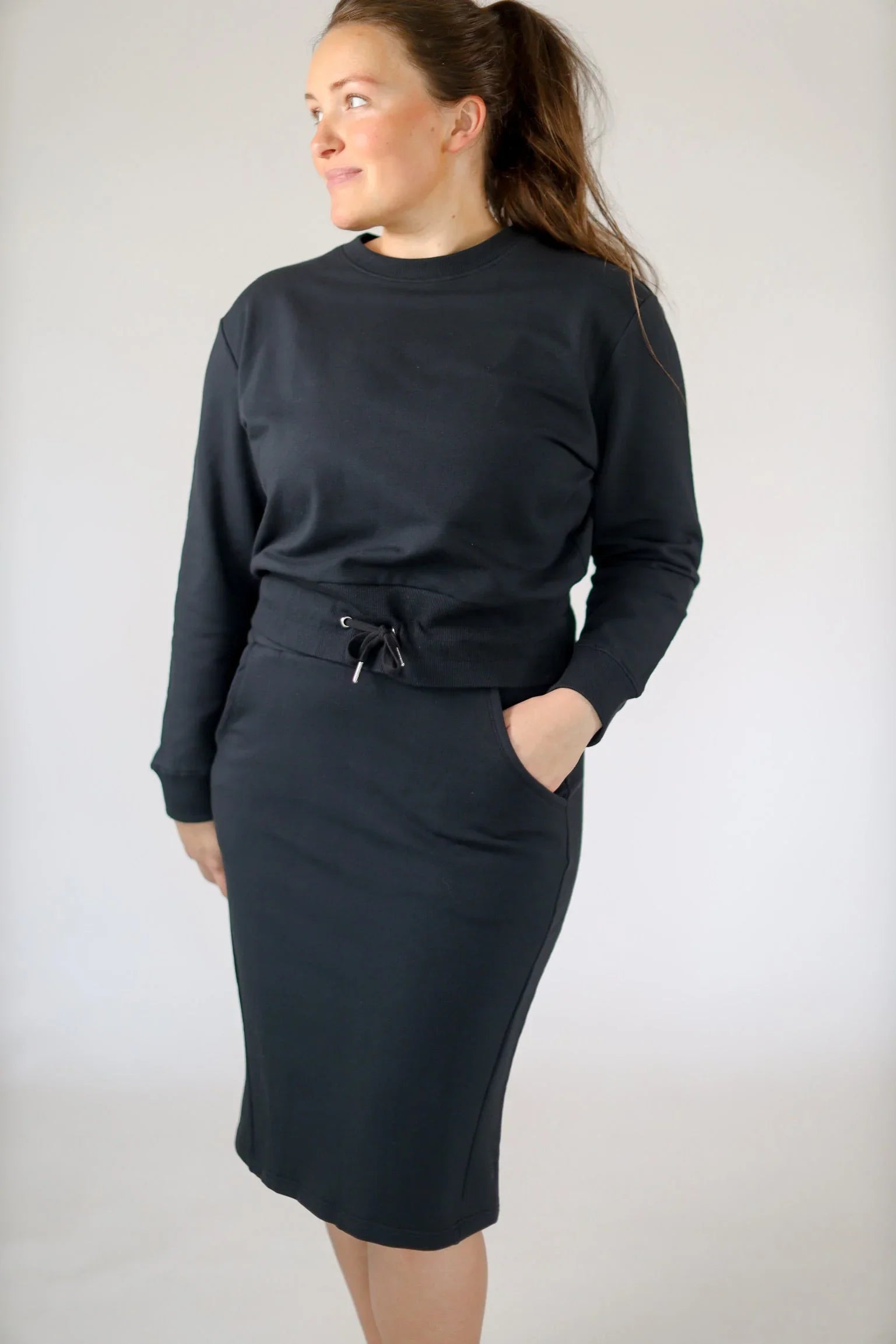 Woman wearing black cropped drawstring pullover sweatshirt by Snoga Athletics