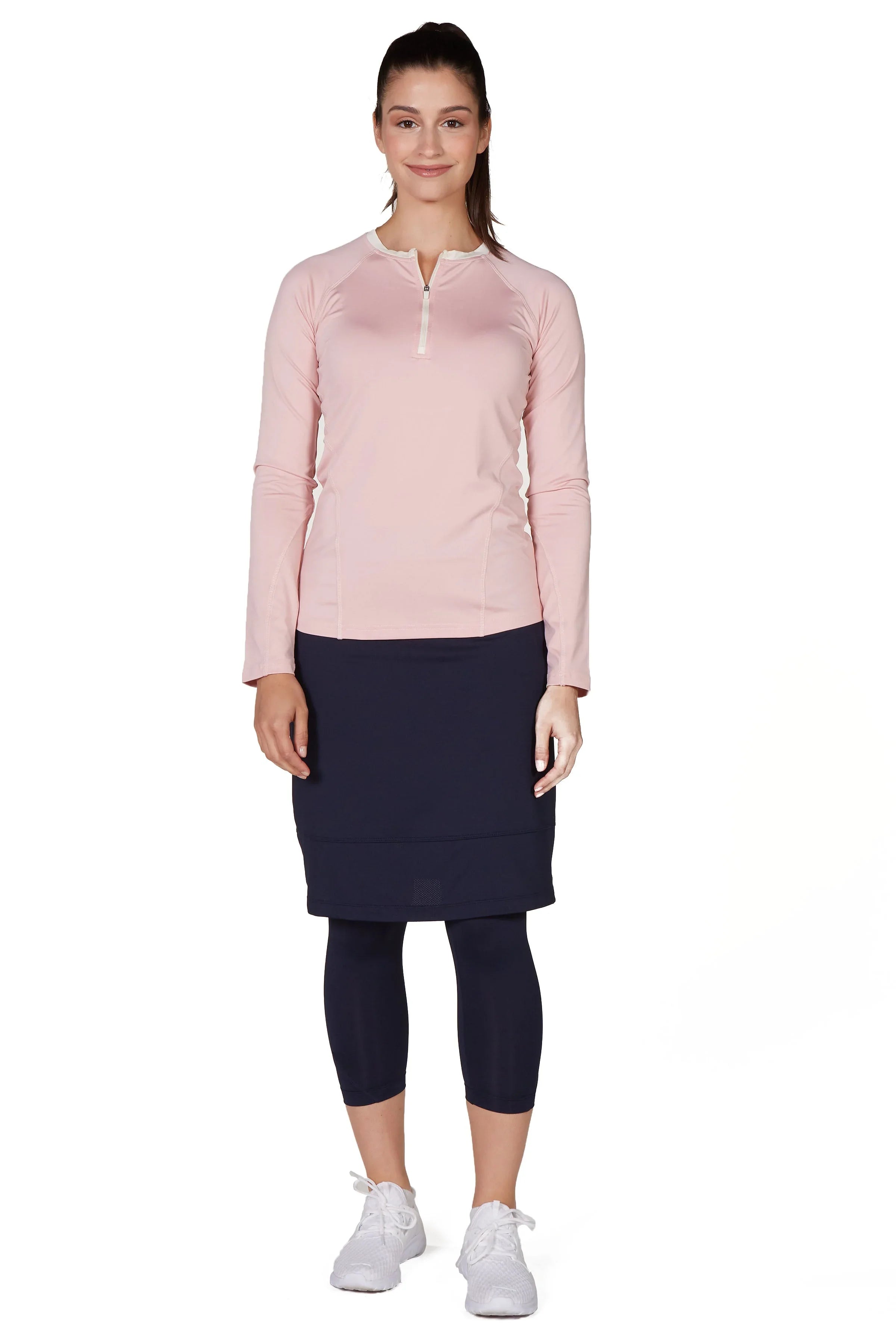 Woman modeling Snoga Athletics modest activewear set with navy skirt leggings and a pink zip-up long sleeve top.