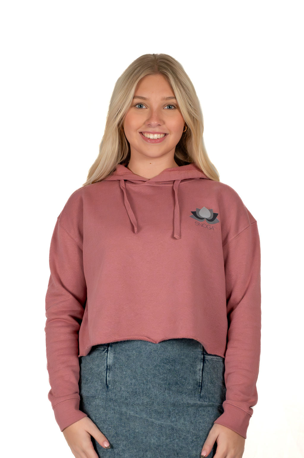 Woman wearing Snoga Athletics cropped mauve hoodie and denim skirt, smiling