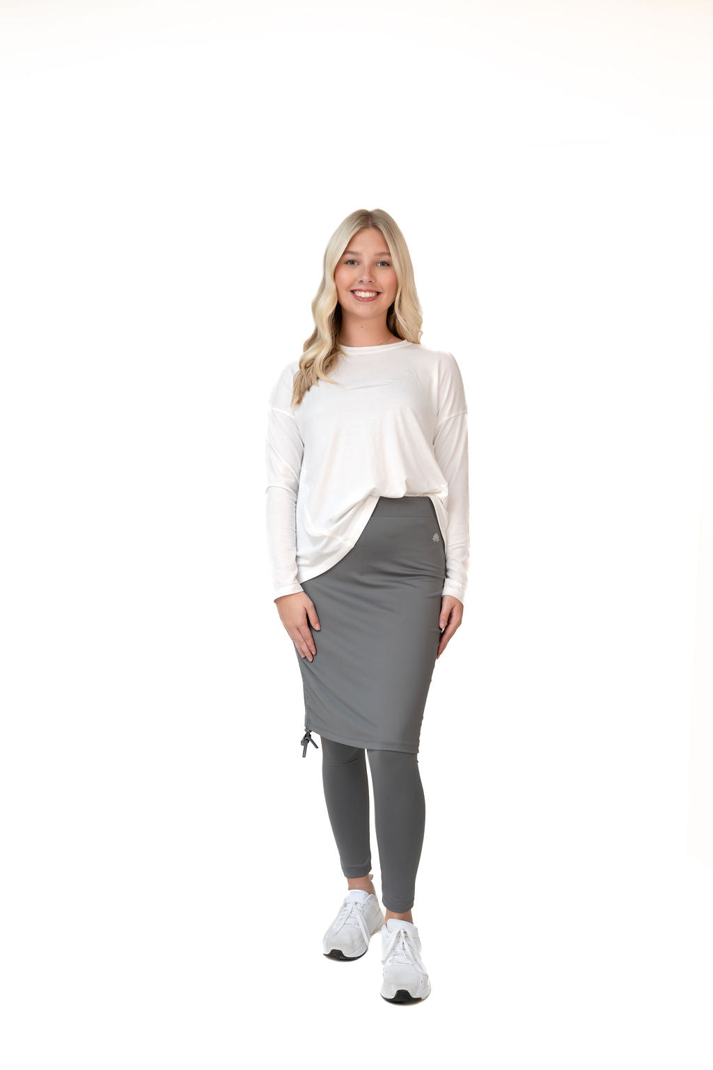 Woman in Snoga Athletics modest activewear, gray skirt leggings, white long sleeve top