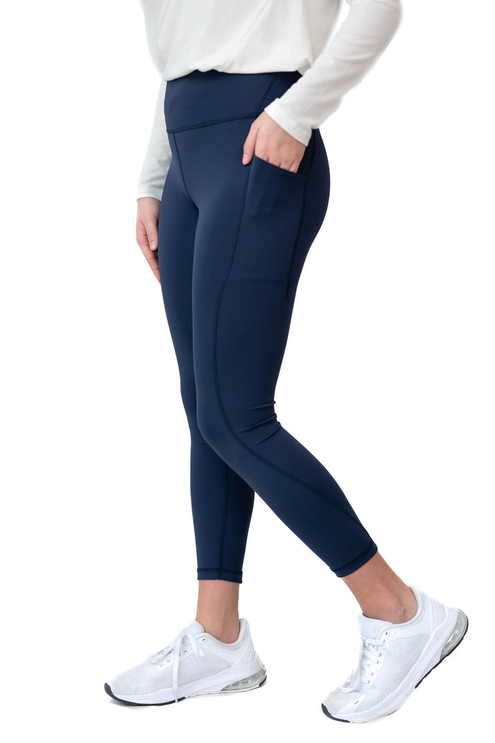 Woman wearing navy blue Snoga Athletics leggings with pockets and white sneakers