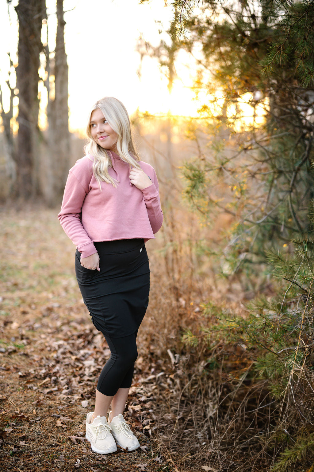 Woman outdoors in Snoga Athletics modest activewear, pink sweatshirt and black skirt leggings