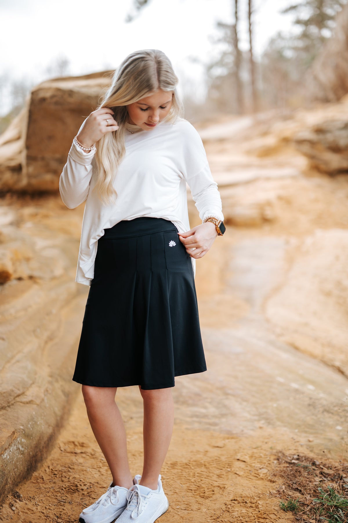 Woman outdoors in a black modest athletic skirt and white top by Snoga Athletics