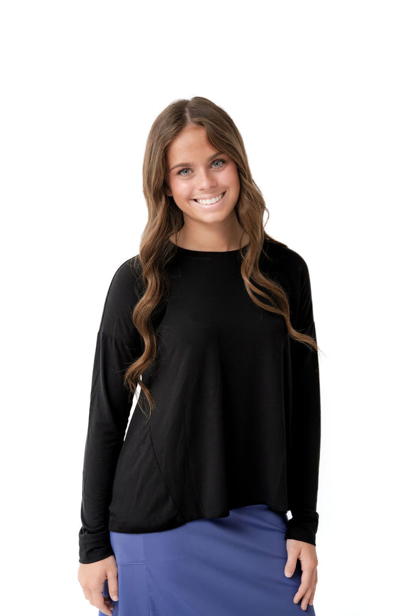 Woman wearing Snoga Athletics black long sleeve top and blue skirt, modest activewear