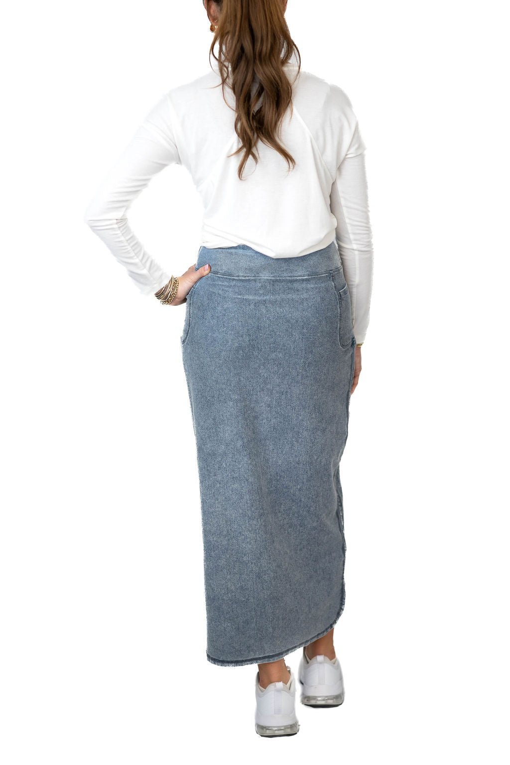 Snoga Athletics woman wearing a modest denim maxi skirt and white top, viewed from back