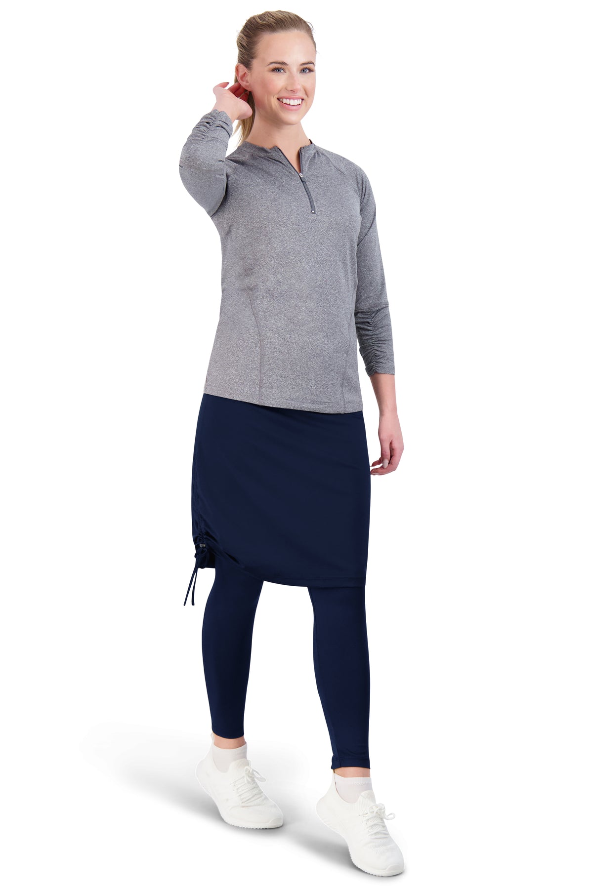 Woman in Snoga Athletics modest activewear with grey top, navy skirt leggings, and white sneakers