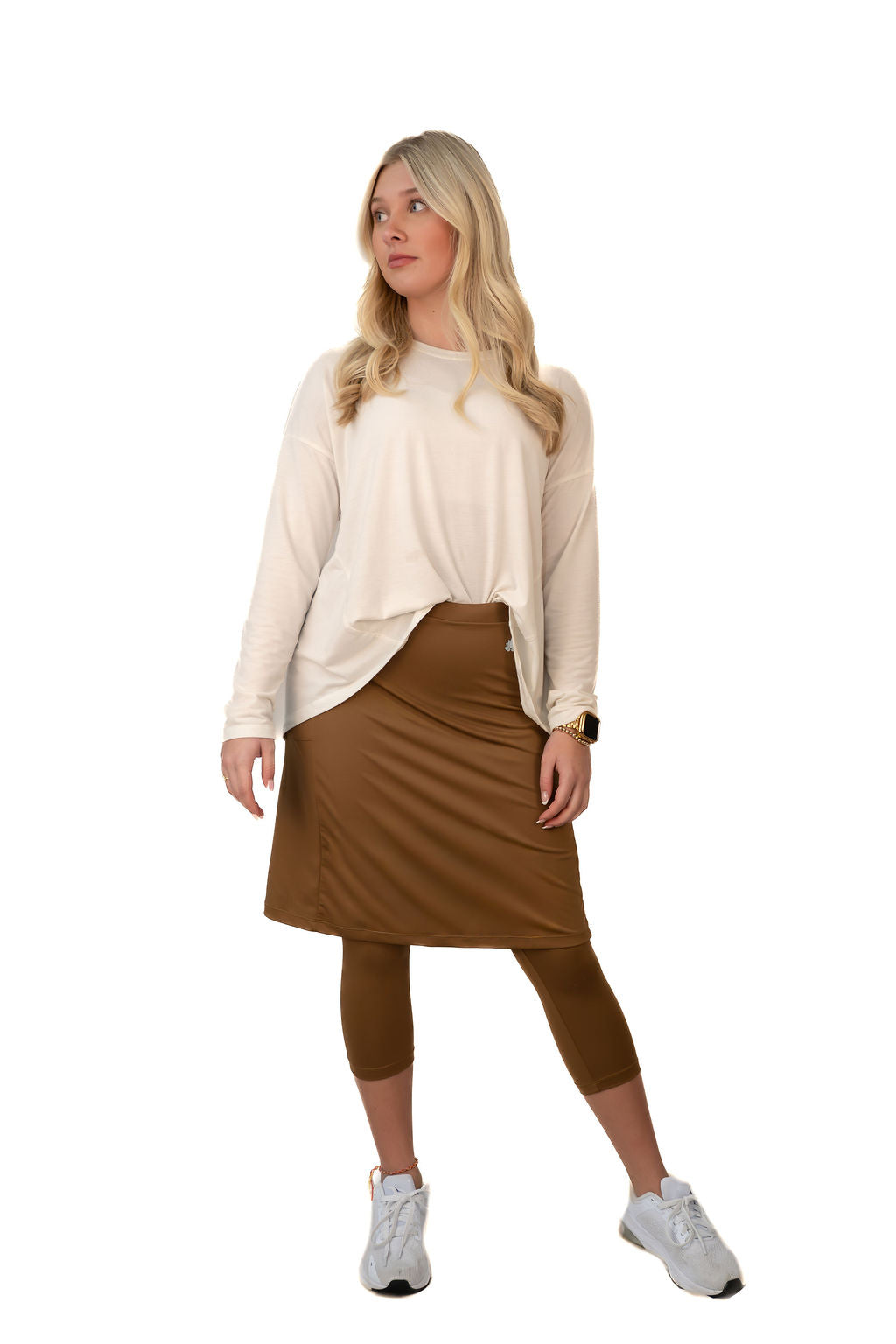 Woman wearing a modest brown skirt with leggings by Snoga Athletics, styled with a cream top.