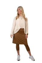 Woman wearing a modest brown skirt with leggings by Snoga Athletics, styled with a cream top.
