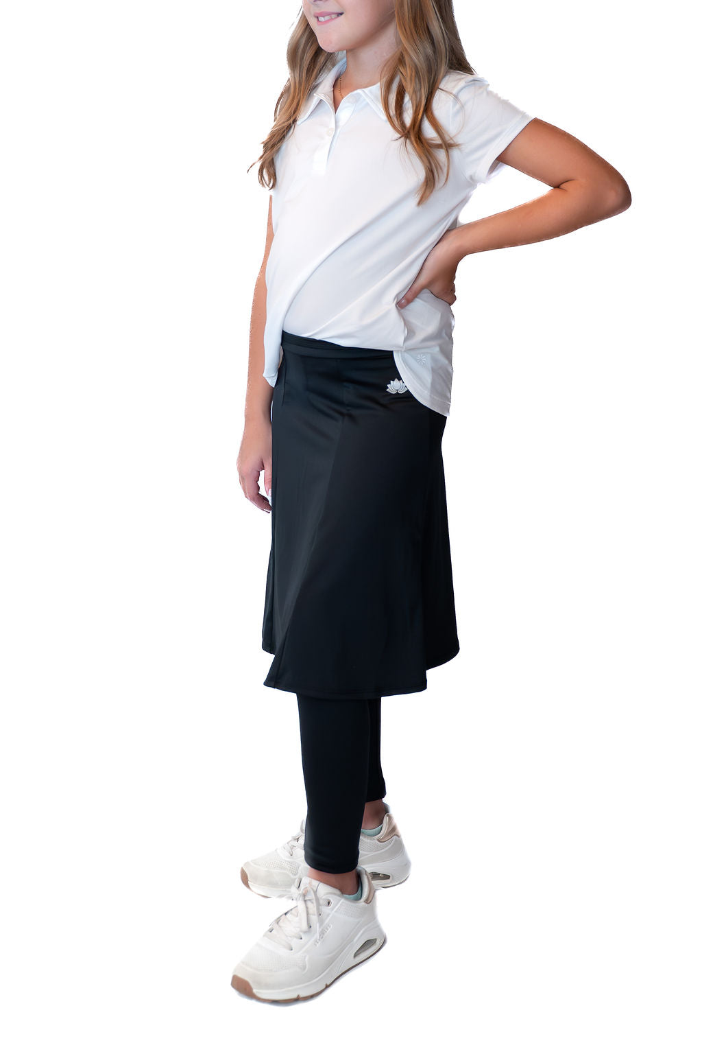 Girl modeling Snoga Athletics black modest skirt with attached leggings and white polo shirt