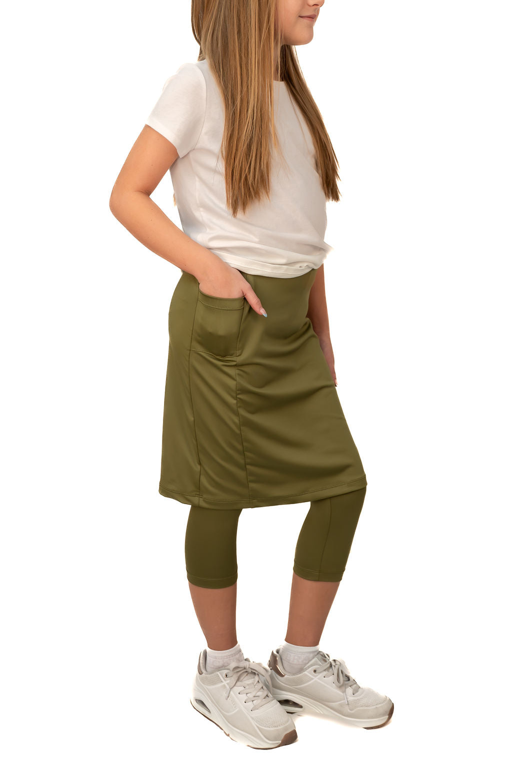 Child in Snoga Athletics olive green modest skirt leggings, white shirt, and sneakers