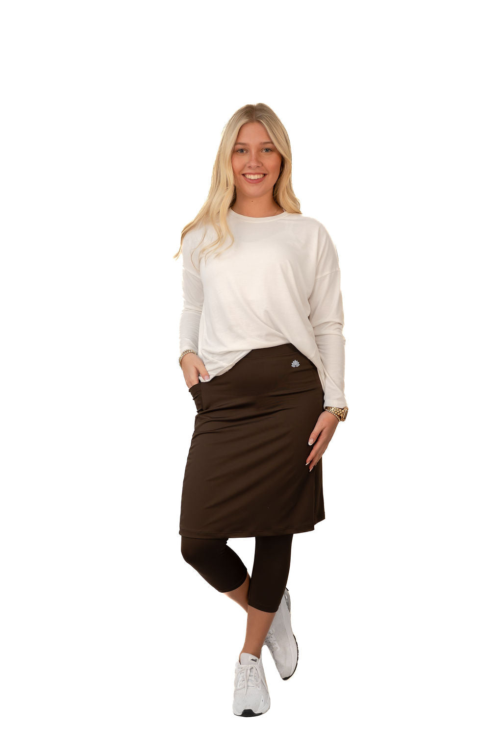 Woman in Snoga Athletics brown modest skirt leggings and white top, activewear fashion