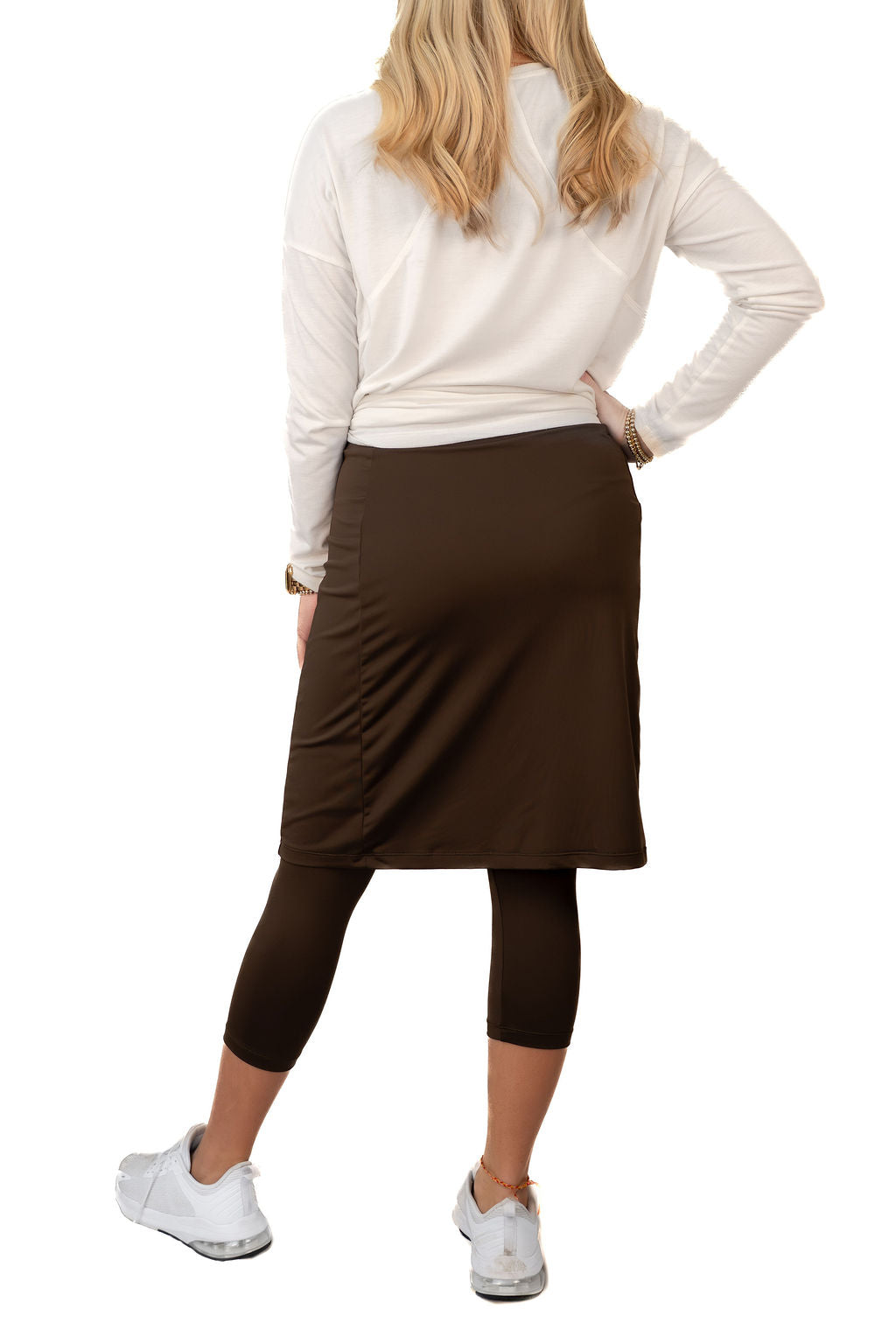 Woman wearing Snoga Athletics brown modest skirt with built-in leggings, white top and sneakers