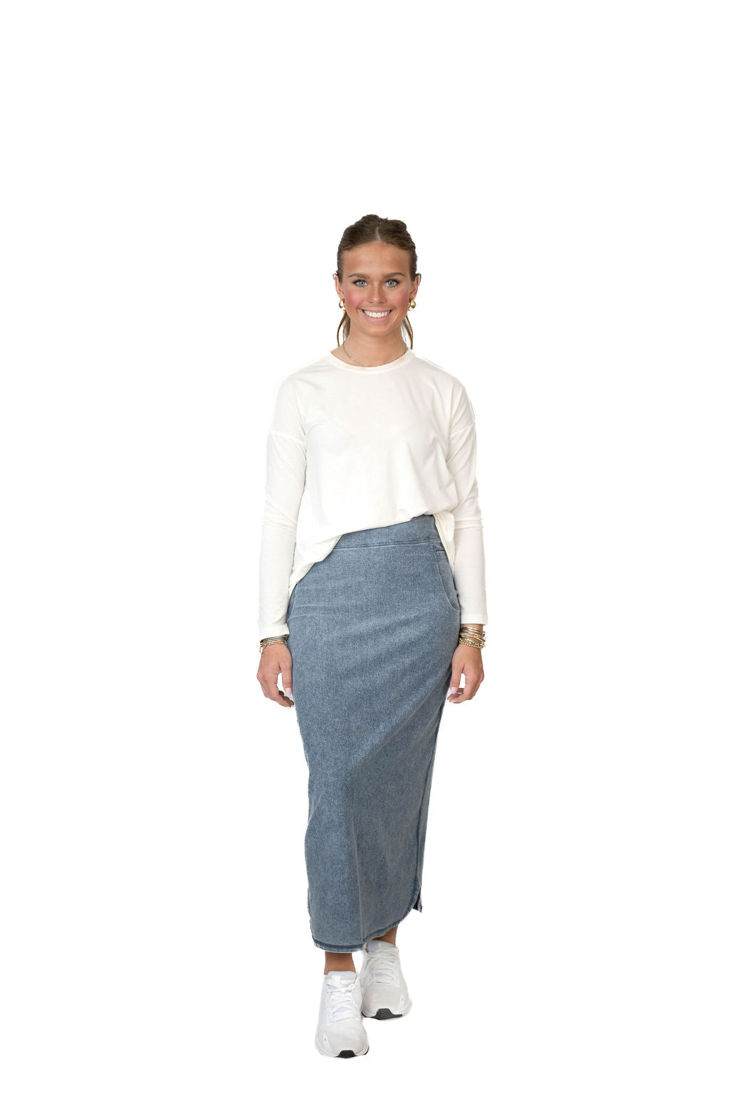 Woman modeling Snoga Athletics modest denim skirt with white long-sleeve top and sneakers