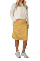 Snoga Athletics model in yellow activewear skirt with pockets, white top, and sneakers