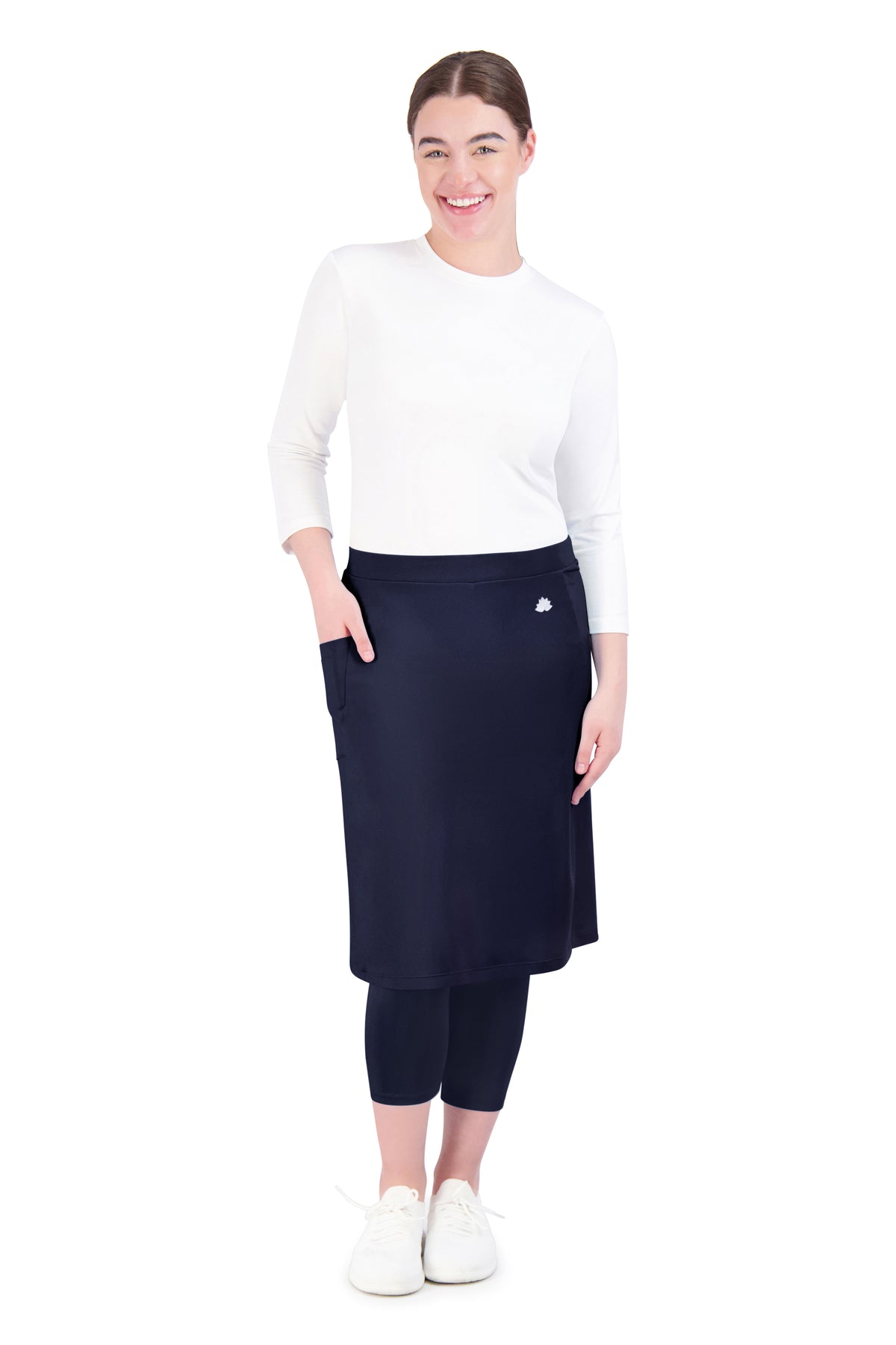 Woman modeling Snoga Athletics modest navy skirted leggings with white top and sneakers
