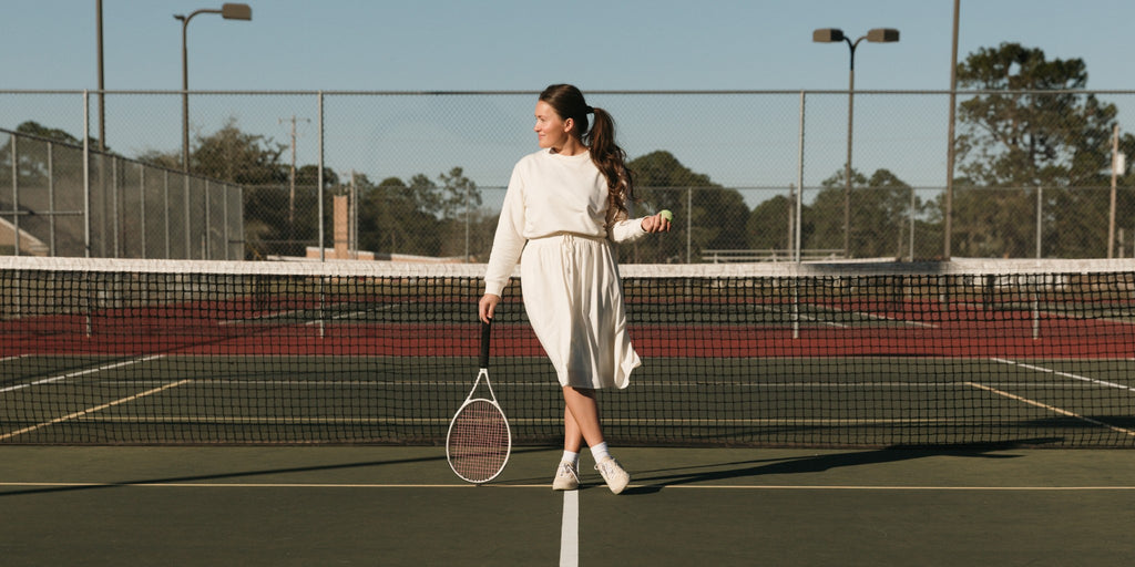 Young woman in an activewear dress on a tennis court