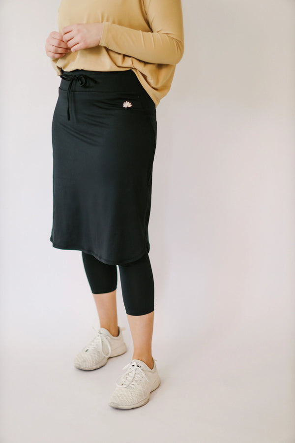 Woman wearing Snoga Athletics black drawstring capri modest skirt with capri leggings
