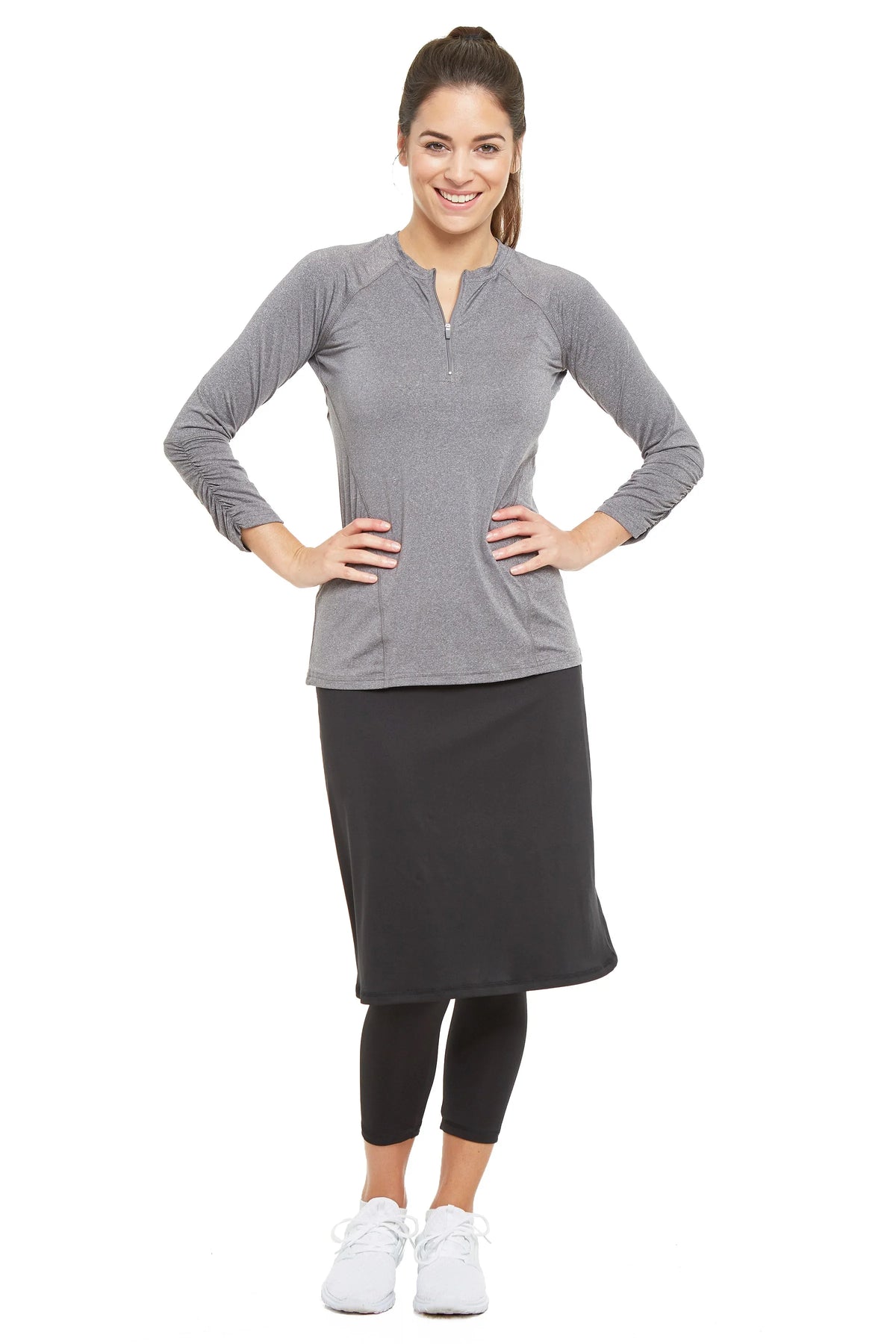 Woman wearing Snoga Athletics black cropped skirt leggings and gray zip-up top