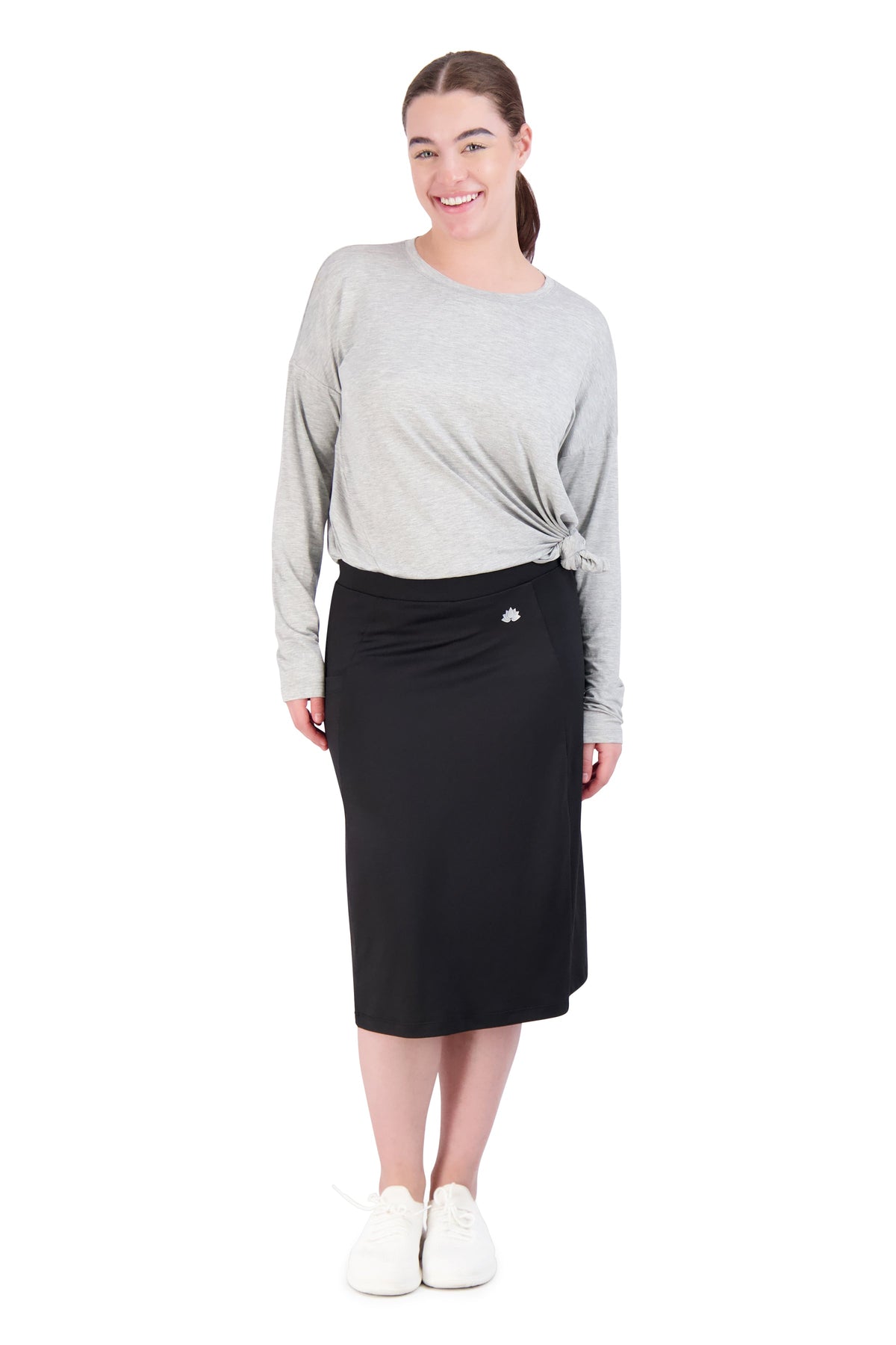 Woman wearing Snoga Athletics black midi active skirt with attached shorts and grey top