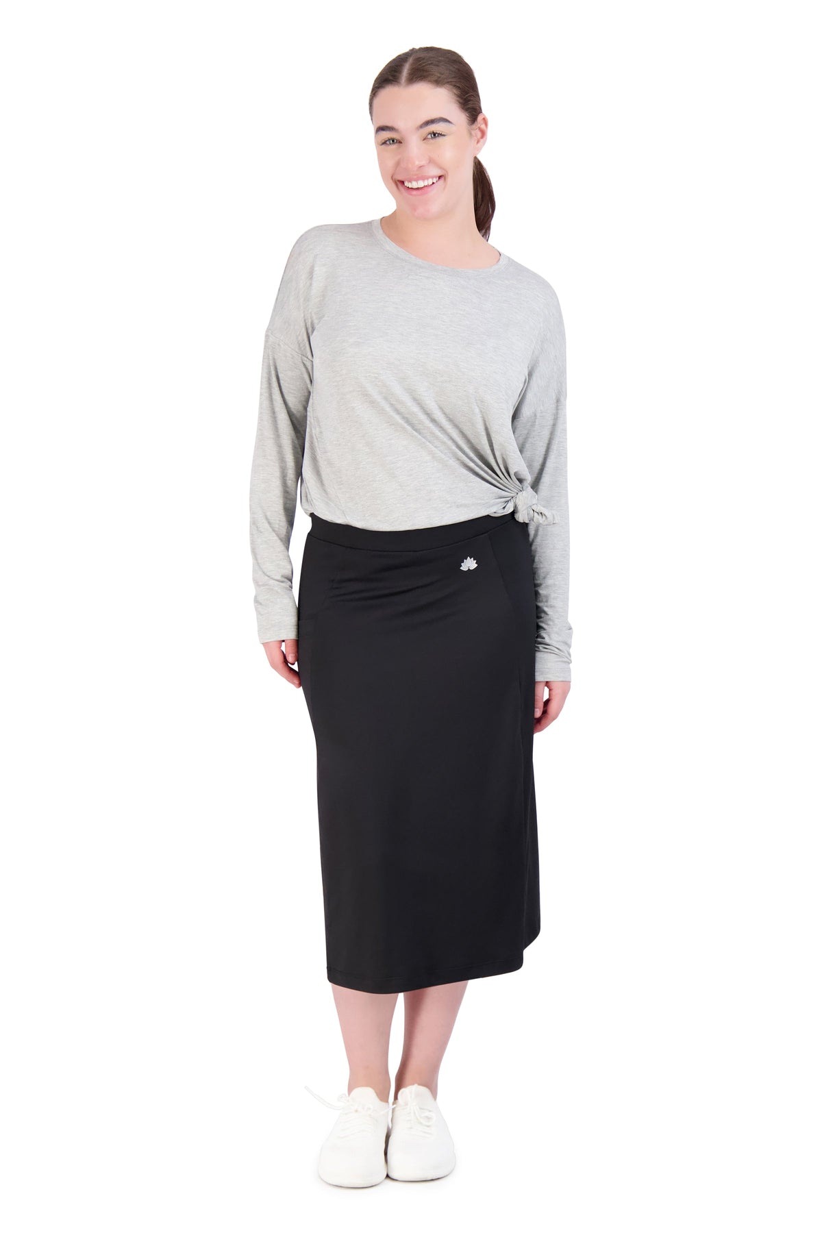 Woman wearing Snoga Athletics black active midi skirt with attached shorts and a grey top