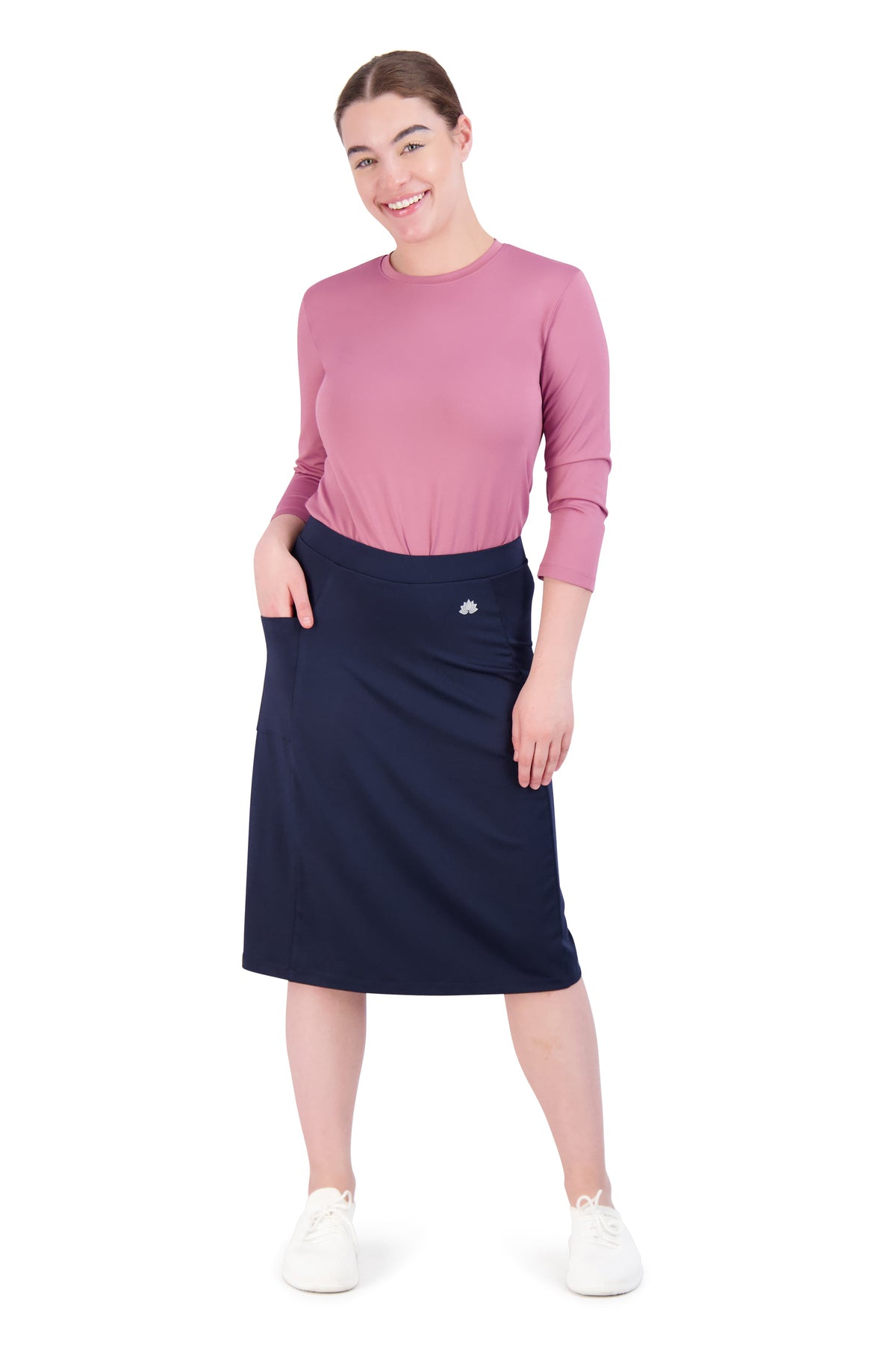 Woman wearing Snoga Athletics navy bike shorts fit skort with pockets, pink top, white shoes
