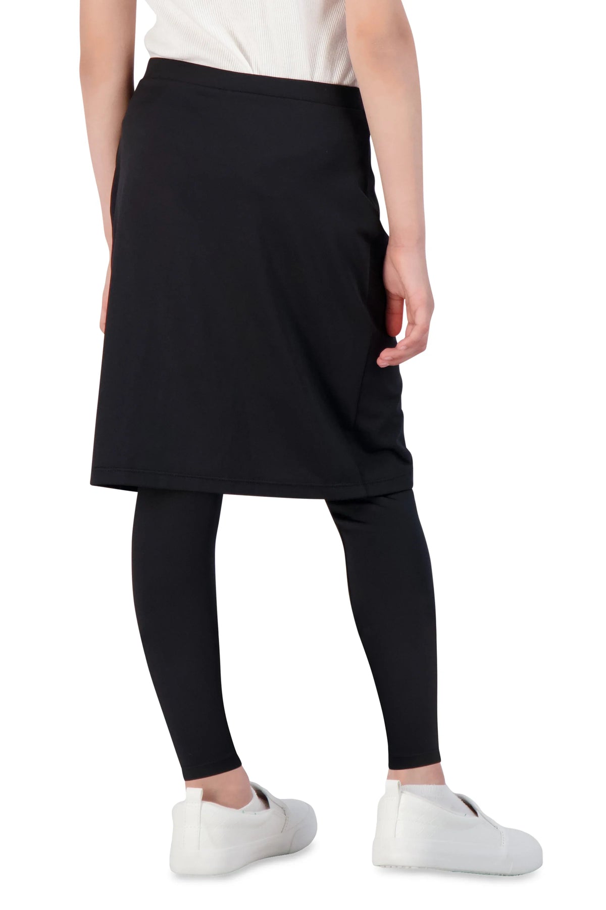 Girl in black faux wrap ankle skirt leggings by Snoga Athletics, white shoes, back view