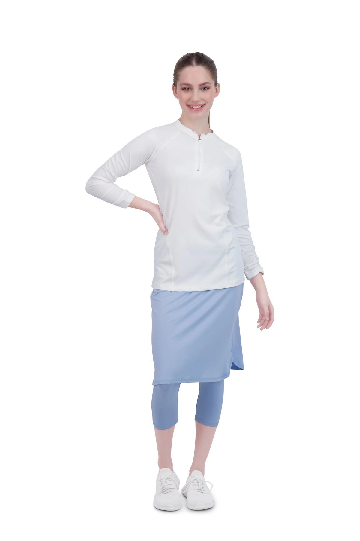 Woman in Snoga Athletics white long sleeve active top and blue modest skirt leggings set