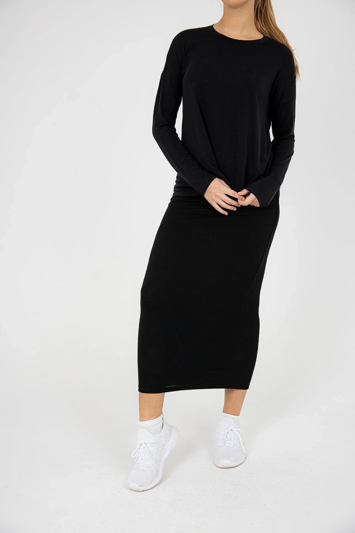 Woman wearing black long sleeve t-shirt and modest black skirt by Snoga Athletics