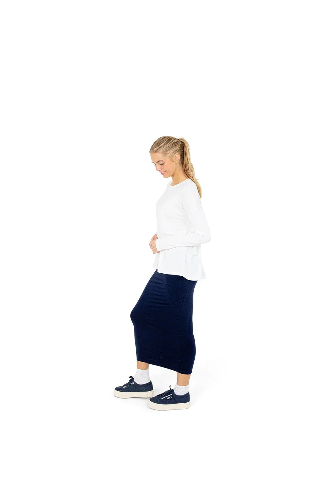 Woman in Snoga Athletics navy t-shirt skirt and white top, side view, athletic shoes